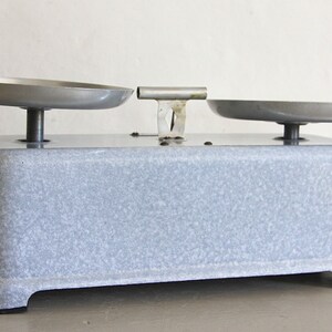 May include: A vintage gray kitchen scale with two metal bowls. The scale has a speckled gray finish and a metal base.