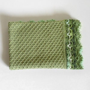 May include: A green crocheted baby blanket with a white and green crocheted border.