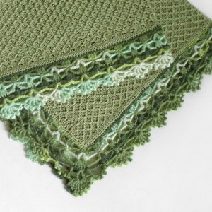 May include: A green crocheted blanket with a delicate lace border. The blanket is made with a textured stitch and has a soft, flowing design.