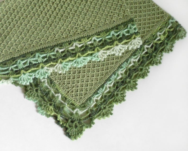 May include: A green crocheted blanket with a delicate lace border. The blanket is made with a textured stitch and has a soft, flowing design.