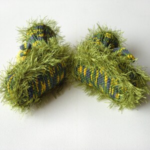 May include: A pair of green, yellow, and gray knitted baby booties with a fuzzy texture.