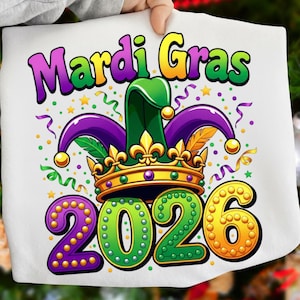 May include: White fabric with a colorful Mardi Gras design. The design includes the words "Mardi Gras" in purple and yellow, a green and purple jester hat, a gold crown, and the year "2026" in purple, green, and gold.