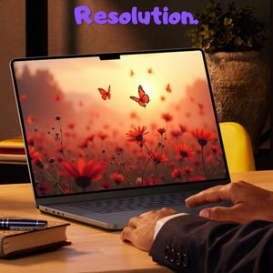 Puede incluir: Un portátil muestra una imagen de flores rojas y mariposas naranjas. El texto en la pantalla dice "Beauty at Full Resolution". Una mano está en el panel táctil. Un bolígrafo y un libro están en el escritorio.