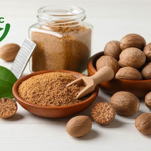 Puede incluir: Disposición de nuez moscada orgánica y nuez moscada molida. Las nueces moscadas enteras están en un cuenco de madera, y la nuez moscada molida está en un tarro de cristal y un cuenco de madera pequeño. También hay un rallador y una cuchara de madera.