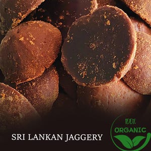 Puede incluir: Primer plano de jaggery de Sri Lanka, un edulcorante orgánico de color marrón oscuro. La imagen muestra varias piezas redondeadas con una superficie texturizada y una parte superior oscura y brillante. El texto "SRI LANKAN JAGGERY" está en la parte inferior, junto con un logotipo "100% ORGANIC".