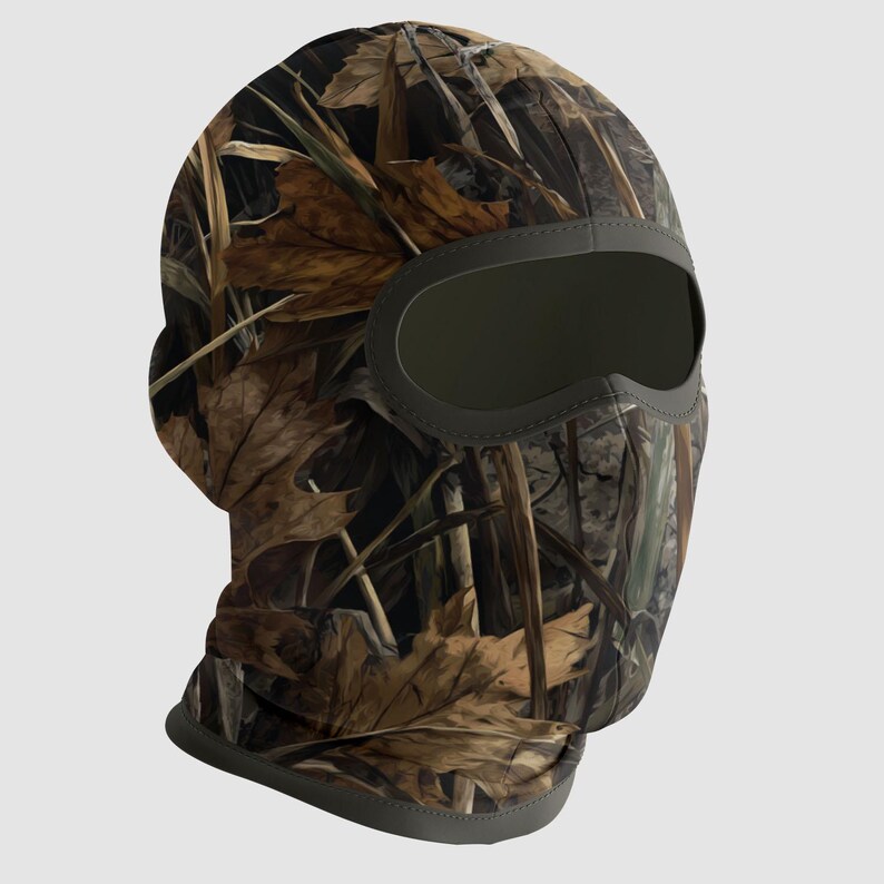 May include: A camouflage balaclava featuring a pattern of brown leaves and green foliage. The balaclava has a dark green eye opening and trim, designed to conceal the wearer's face and head. Ideal for outdoor activities.