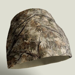 May include: A camouflage beanie hat with a forest pattern in brown, green, and tan. The hat has a rounded shape and a textured, light-coloured interior. The camouflage design blends branches and leaves.