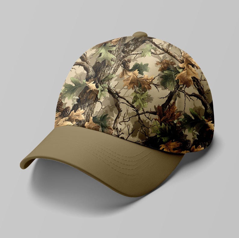 K&ouml;nnte beinhalten: Baseballcap mit einem Tarnmuster aus braunen, gr&uuml;nen und beigen Bl&auml;ttern und &Auml;sten. Der Schirm ist einfarbig beige. Die Kappe hat einen gebogenen Schirm und einen Knopf oben.