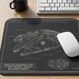 May include: A black rectangular mouse pad featuring a white technical schematic of a Corellian YT-1300 light freighter. The design includes detailed line drawings, labels, and the text Corellian Engineering Corp - YT-1300 Technical Readout - Multiview Schematic.