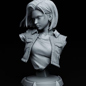 Può includere: Un busto scultoreo grigio monocromatico di un personaggio con capelli corti, che indossa un gilet con colletto sopra una maglietta. La figura ha un'espressione seria ed è montata su una base circolare. Il testo TANUKI FIGURES è visibile in alto a sinistra.