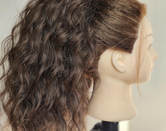 May include: A mannequin head with brown, wavy hair styled in a high ponytail. The hair is a rich, dark brown color with visible curls and waves. The mannequin's face is turned to the side, showcasing the hairstyle.