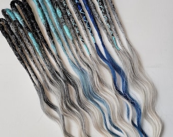 May include: A collection of dreadlocks in various shades of gray, black, and blue. The dreads have a wavy, textured appearance and are arranged in a fan-like pattern. Some dreads are accented with turquoise and blue thread.
