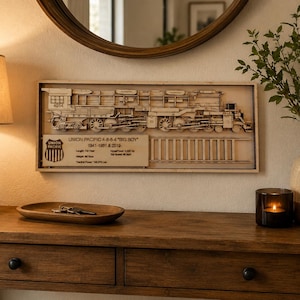 May include: A rectangular wooden wall art piece featuring a laser-cut layered depiction of a Union Pacific 4-8-8-4 Big Boy steam locomotive. The artwork includes the train, tracks, and a plaque with technical specifications and the Union Pacific logo.