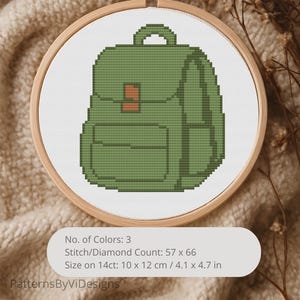 May include: A cross-stitch pattern of a green backpack in a wooden embroidery hoop. The design includes a front pocket and a top handle. The text on the image reads: No. of Colors: 3, Stitch/Diamond Count: 57 x 66, Size on 14ct: 4.1 x 4.7 in, and PatternsByViDesigns.