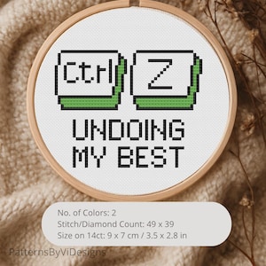 May include: A cross-stitch embroidery hoop with the text "Ctrl Z UNDOING MY BEST". The design features pixelated green and black keyboard keys. The hoop is 3.5 x 2.8 inches in size and is set against a neutral background.