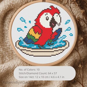 May include: Cross-stitch embroidery of a red parrot in water, framed in a wooden hoop. The parrot has a white beak and is surrounded by blue water splashes. The design is 4.6 x 4.1 inches. The text "PatternsByViDesigns" is at the bottom.