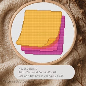 May include: A cross-stitch embroidery in a wooden hoop features a stack of sticky notes in shades of yellow, pink, and purple. The design is on white fabric. The text on the image reads "No. of Colors: 7", "Stitch/Diamond Count: 67 x 61", and "Size on 14ct: 4.8 x 4.4 in".