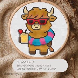 May include: A cross-stitch embroidery in a wooden hoop features a pixelated Highland cow wearing red sunglasses and a striped scarf. The cow holds a cupcake. The design is 3.1 x 3.9 inches. The text reads "PatternsByViDesigns".