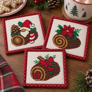 May include: Three square coasters featuring cross-stitch designs on a cream background with red stitched borders. One shows a gnome with a pinecone and candy cane, one a poinsettia on a log, and one a log with a red bow and holly berries.