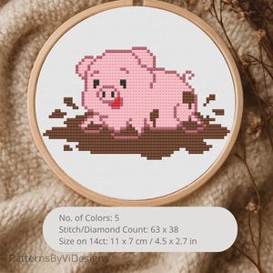 Può includere: Un ricamo a punto croce di un maialino rosa che rotola nel fango marrone, posto all'interno di un cerchio di legno. Il disegno è su tessuto bianco. Il testo sull'immagine recita: Numero di colori: 5, Conteggio punti: 63 x 38, Dimensioni su 14ct: 11 x 7 cm.