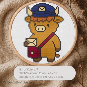 Op de afbeelding: Een kruissteekontwerp van een cartoon Highland-koe met een blauwe hoed en een postzak. Het ontwerp zit in een houten borduurring. De tekst op de afbeelding luidt: "No. of Colors: 7, Stitch/Diamond Count: 41 x 61, Size on 14ct: 7 x 11 cm."