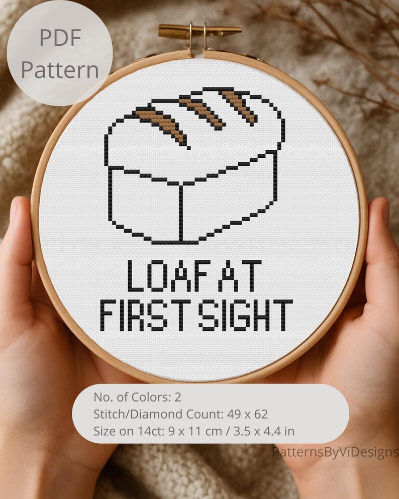 May include: A cross-stitch pattern in a wooden hoop features a pixelated loaf of bread with the text "LOAF AT FIRST SIGHT". The pattern includes the text "PDF Pattern" and details: 9 x 11 cm / 3.5 x 4.4 in. A craft project.