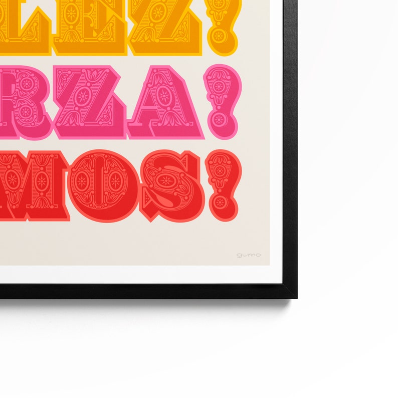 Op de afbeelding: Een ingelijste kunstdruk met drie regels dikke, decoratieve typografie in geel, roze en rood tegen een lichtcr&egrave;me achtergrond. De tekst luidt "ALEZ!", "FORZA!" en "AMOS!" met ingewikkelde bloemmotieven in elke letter.