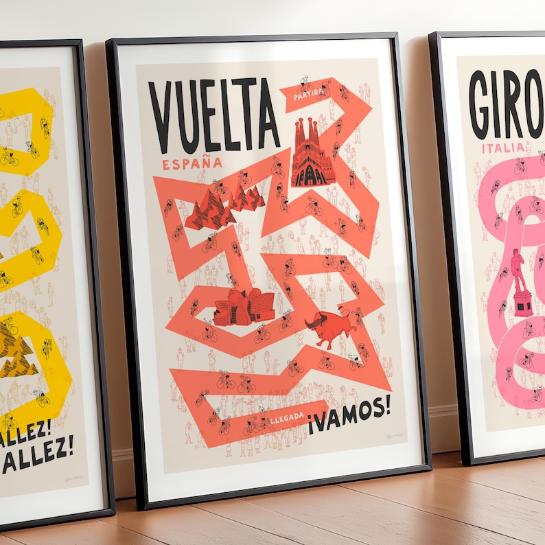 Set of three Grand Tour cycling posters—Giro, Tour, and Vuelta, focussing on Vuelta design in the centre and the Tour and Giro designs partly cropped on either side. Shown framed and leaning against a wall, the design features the race route in red on a neutral background, along with fun illustrations of cyclists, spectators and famous Spanish landmarks.