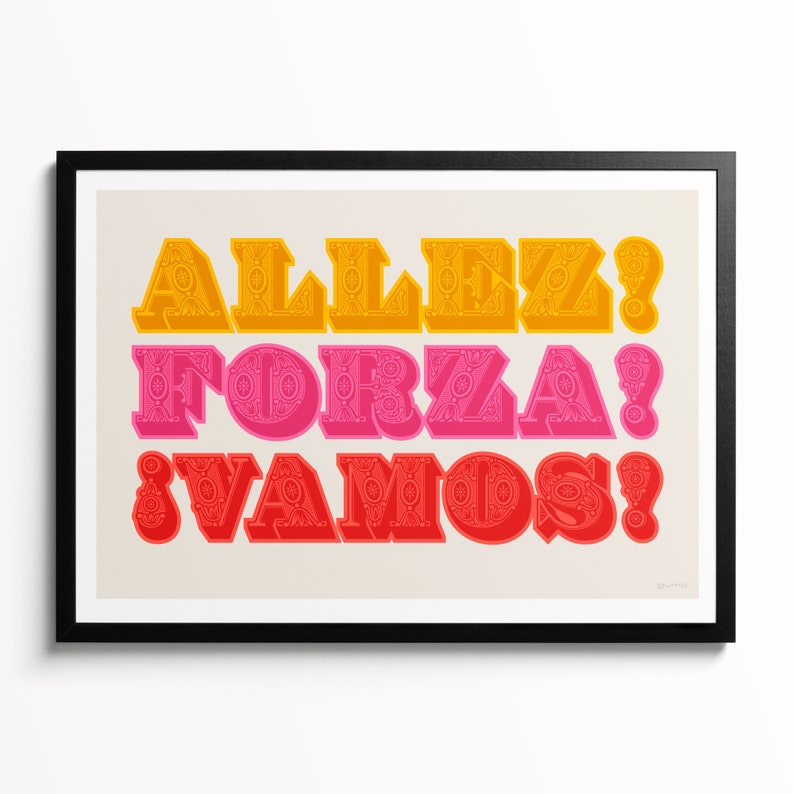 Op de afbeelding: Een ingelijste kunstdruk met drie regels tekst in een vet, decoratief lettertype. De bovenste regel toont ALLEZ! in het geel, de middelste regel FORZA! in het roze en de onderste regel &iexcl;VAMOS! in het rood, op een lichte achtergrond.