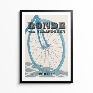 May include: A framed poster featuring a light blue bicycle wheel and fork against a cream background. The text RONDE van VLAANDEREN appears in dark, patterned block letters, with the text 'De Ronde' printed in black at the bottom of the print.