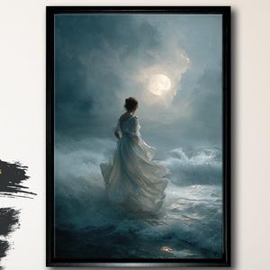 May include: Black framed canvas art print. The artwork depicts a woman in a flowing white dress standing in the ocean, facing a bright moon. The canvas is made of 100% cotton (300 g/m²) and is ready to hang.