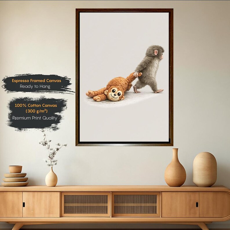 May include: A framed canvas print showing a baby monkey dragging a soft toy monkey. The print is on 100% cotton canvas, 300 g/m&sup2;. The text on the print says "Espresso Framed Canvas Ready to Hang" and "Premium Print Quality."