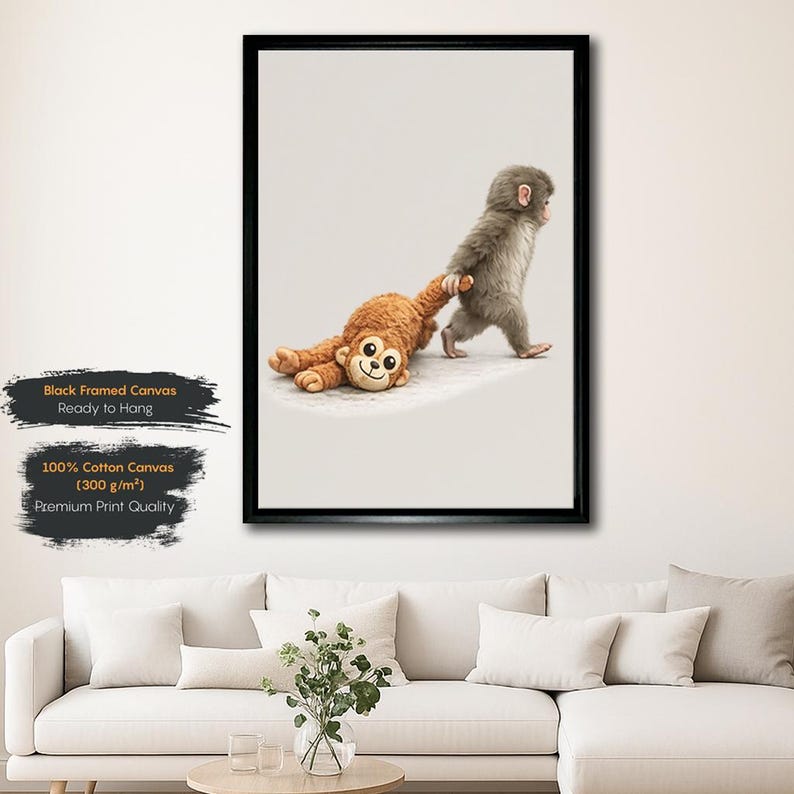 May include: A framed canvas print showing a baby monkey pulling a plush monkey toy. The print is in a black frame and has text that reads "Black Framed Canvas Ready to Hang" and "100% Cotton Canvas (300 g/m&sup2;) Premium Print Quality."