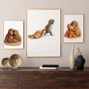 May include: Three framed art prints with charming monkey illustrations. One print shows two monkeys embracing, another depicts a monkey pulling a toy, and the third shows two monkeys cuddling. The prints are in gold frames.