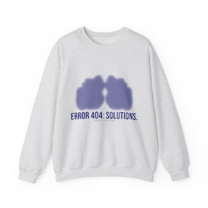 May include: A light grey sweatshirt with a crew neck. The front displays two overlapping purple shapes and the text "ERROR 404: SOLUTIONS." below the shapes. The words "FINDINGS CONCERNING" are below the text.