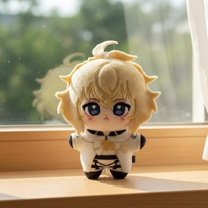 Może przedstawiać: Pluszowa lalka z jasnożółtą głową i włosami, niebieskimi oczami oraz biało-czarnym strojem. Lalka stoi na drewnianej powierzchni w pobliżu okna. Lalka ma uroczy, kreskówkowy wygląd.