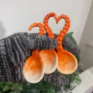 Colher artesanal de cerâmica em formato de tentáculo de polvo, um acessório de cozinha único e original.