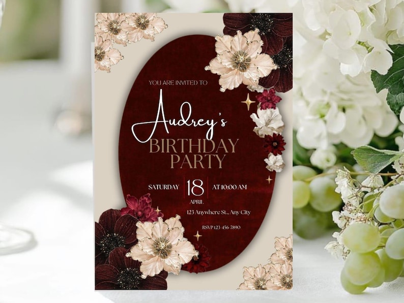 May include: A birthday party invitation with a burgundy oval centerpiece. The invitation features the text "Audrey's BIRTHDAY PARTY" in elegant script. Floral accents in cream, burgundy, and red surround the text. The date is Saturday, April 18th, at 10:00 AM.