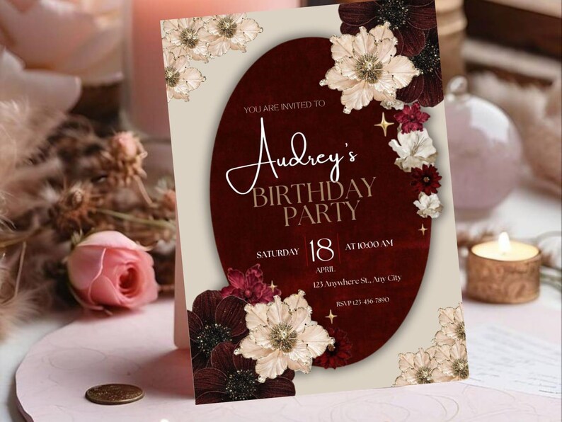 May include: A birthday party invitation with a burgundy oval design, featuring the text "Audrey's BIRTHDAY PARTY". The invitation includes the date, time, and location. Floral accents in cream, burgundy, and white decorate the corners.