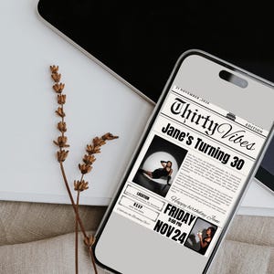 May include: A smartphone displays a birthday invitation with a newspaper theme. The headline reads "Thirty Vibes Jane's Turning 30." The invitation includes a photo, date, time, and location. Dried flowers and a laptop are in the background.