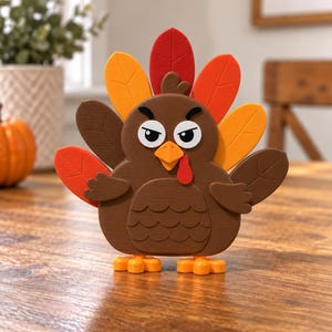 May include: A brown turkey figurine with a textured surface, featuring a fan of red, orange, and yellow tail feathers. The turkey has a yellow beak, a red wattle, and white eyes with black pupils and eyebrows, standing on two orange feet.