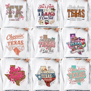 Może przedstawiać: Białe bluzy z różnymi wzorami w stylu Teksasu. Wzory obejmują zarys stanu Teksas, tekst "She's from Texas I can tell" oraz inne grafiki, takie jak długorogi, karty do gry i wiatrak. Odzież codzienna.