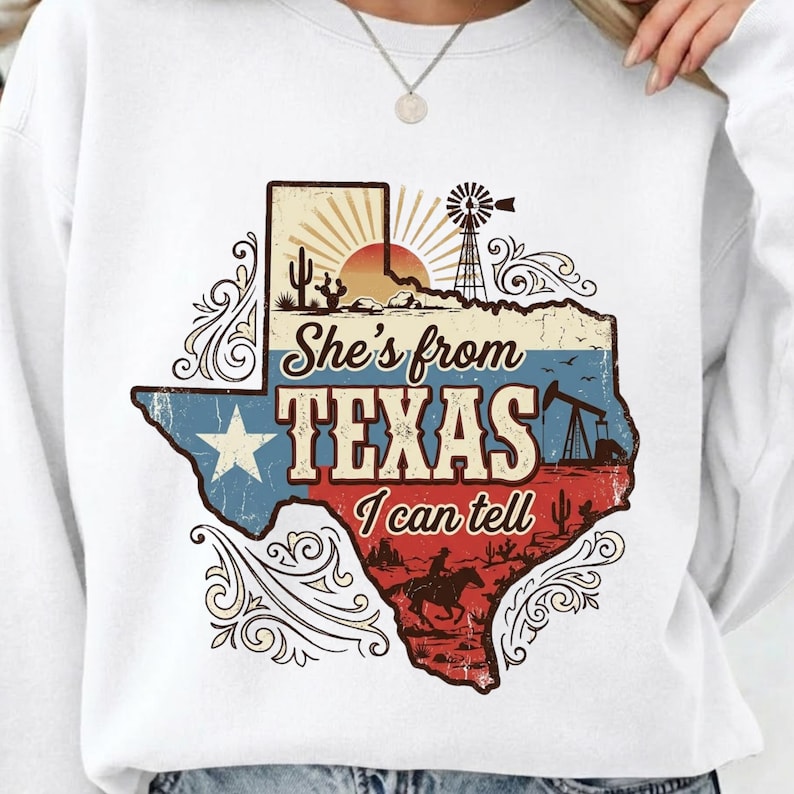 May include: White sweatshirt featuring a distressed graphic of the Texas state outline. The design includes a sunset, windmill, oil derrick, and a cowboy on a horse, with the text "She's from TEXAS I can tell."