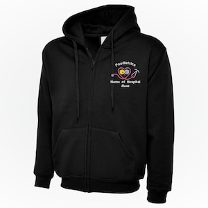 Peut inclure: Sweat à capuche noir zippé avec capuche et poches avant. Le sweat à capuche porte le mot "Paediatrics" au-dessus d'un design coloré de stéthoscope et de cœur. Le texte "Name of Hospital" et "Name" est en dessous.