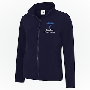 May include: Navy blue fleece jacket with a full zipper and a stand-up collar. The jacket features a blue medical symbol and the text "Landon, Severe injuries" embroidered on the chest. A comfortable and warm outerwear option.