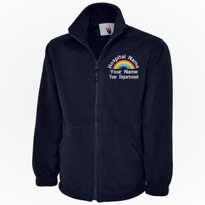 May include: Navy blue fleece jacket with a full zip and a high collar. The jacket features a rainbow graphic and the text "Hospital Name, Your Name, Your Department" in white. It has two front pockets.
