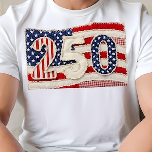 May include: White t-shirt with a patriotic design. The design features a stylized American flag with the number "250" in the centre, celebrating a milestone. The flag incorporates red and white stripes, blue stars, and a gingham pattern.