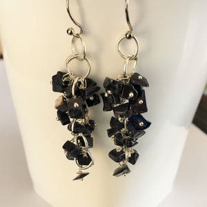 May include: A pair of dangle earrings with black gemstone beads and silver chain links.