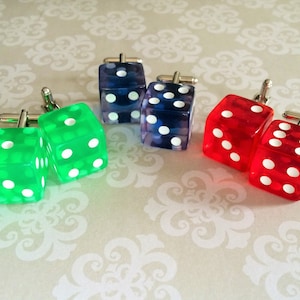 May include: Four pairs of dice cufflinks. Two pairs are green, one pair is red, and one pair is blue.