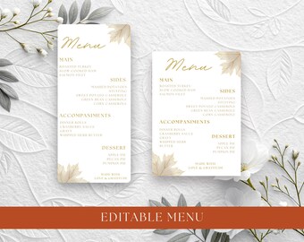 May include: Two white rectangular menu cards featuring gold cursive text and light brown maple leaf illustrations. The menus list sections for Main, Sides, Accompaniments, and Dessert, with the text Made with Love & Gratitude at the bottom.